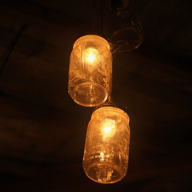 three mason jars hanging from a ceiling in a dark room